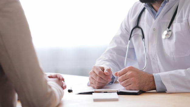 Family doctor and patient talking in medical office.