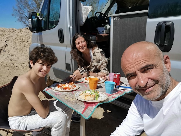 Family enjoying a meal outdoors in a motorhome