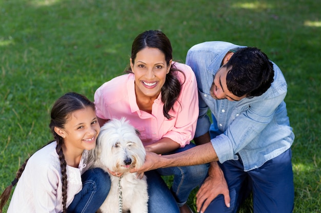 Family enjoying together with their pet dog in park