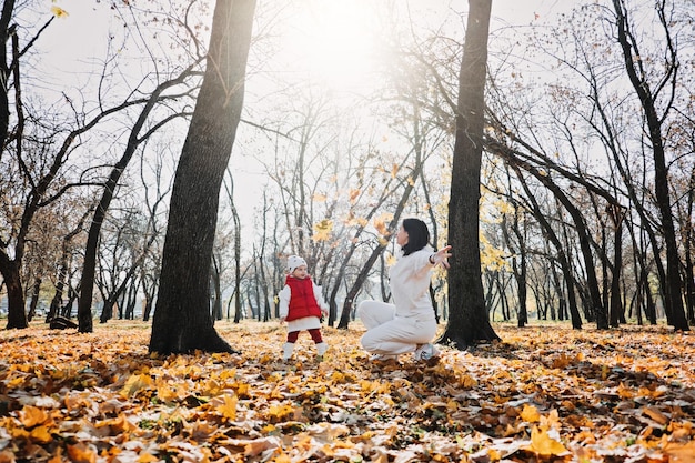 Family fall activities happy family mom and toddler baby girl playing outdoors in fall park