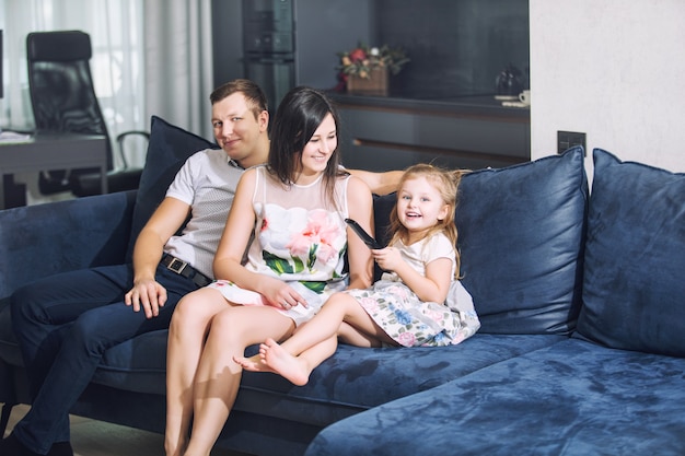 Family father mother daughter together beautiful and happy at home together on the couch