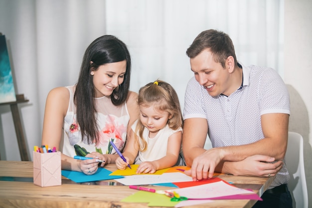 Family father mother daughter together beautiful and happy at home together draw cards