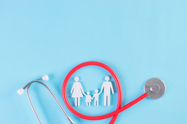 Family figure wrapped with stethoscope on light blue background. Insurance or Covid-19 concept.