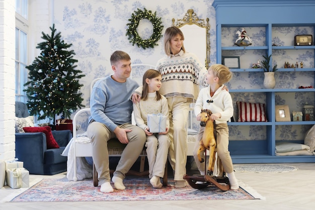 A family of four pose in a Christmas interior Family communicates with each other