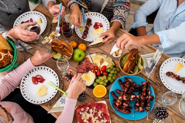 Family friends have fun together in winter eating food on a wooden table