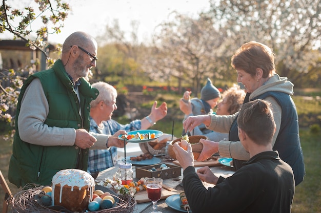 The family gathered at a festive table in the garden to celebrate easter