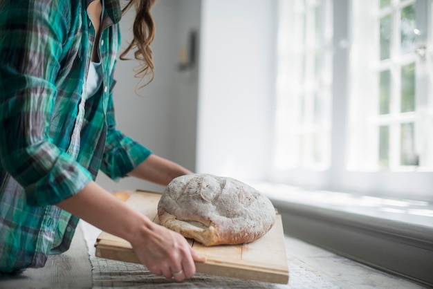 Photo a family gathering a woman carrying a fresh baked loaf of bread