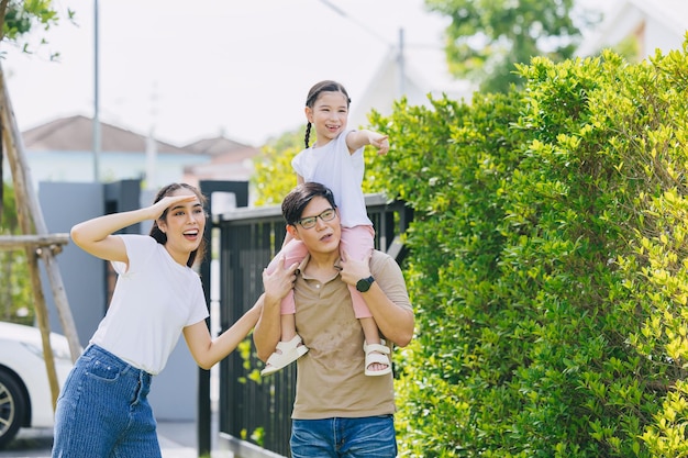 Family group of Asian people happy together outdoors with child enjoying playful fun to explorer