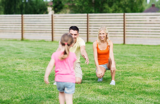 family, happiness, adoption and people concept - happy little girl running towards father and mother outdoors