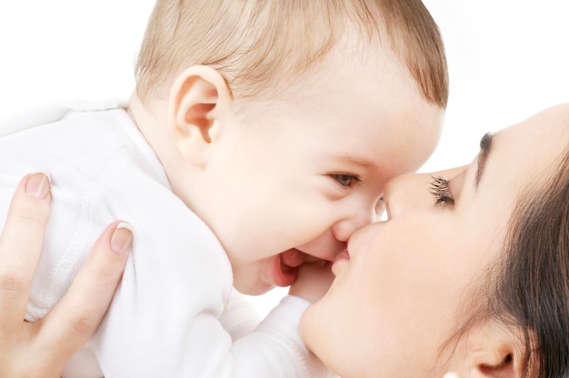 family and happy people concept - mother kissing her baby