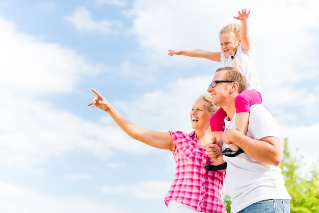 Family having summer walk on meadow outdoors