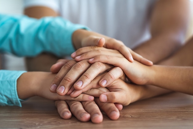 The family hold hands together at the table