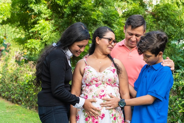 Family holds mother39s hands on her pregnant belly