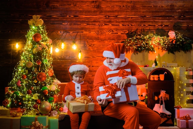 Family holiday concept santa claus man and little santa boy at home christmas decoration christmas