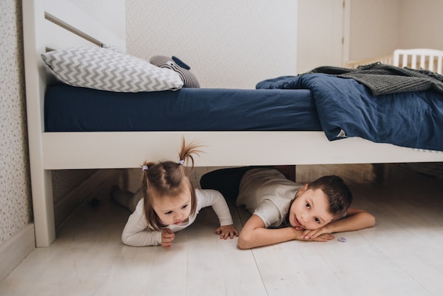 Photo family at home in pajamas. daughter and son. wake up in the morning. hugging and kissing in the bedroom on the bed.