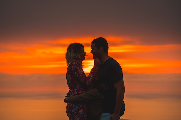 Family hugging on the top of a mountain at sunset