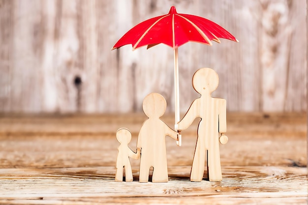 Photo family insurance and safety concept wooden figure with umbrella icon for protection and care