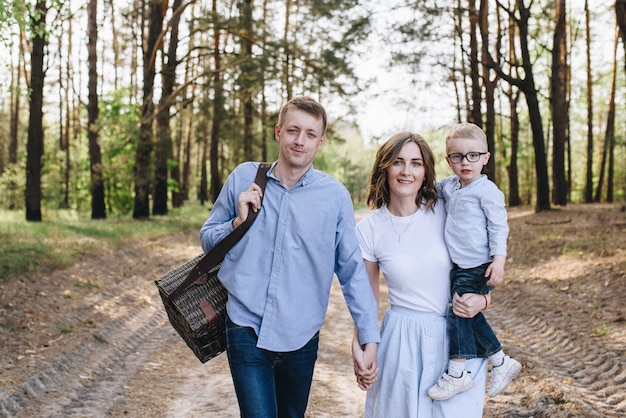 The family is going on a picnic in the forest. Mom, dad, son. Su