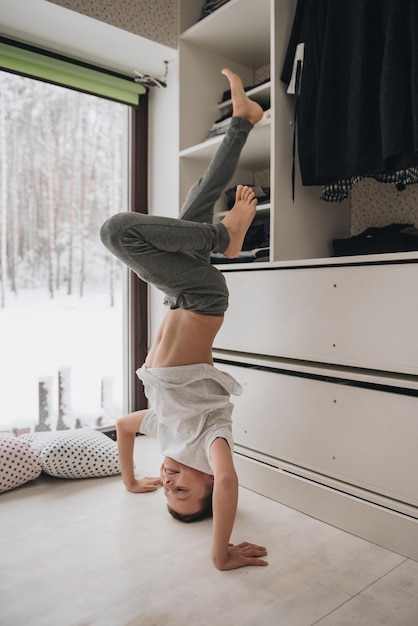 The family is sitting at the window and looking at the winter forest. Good New Year spirit. Morning in pajamas.