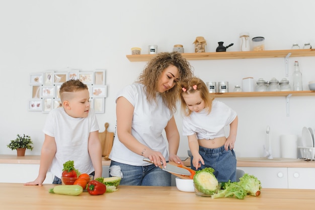 Family in a kitchen. Beautiful mother with children. Lady in white blouse.