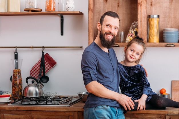 Family leisure. Happy father and his cute little daughter enjoying spending time together in home kitchen.