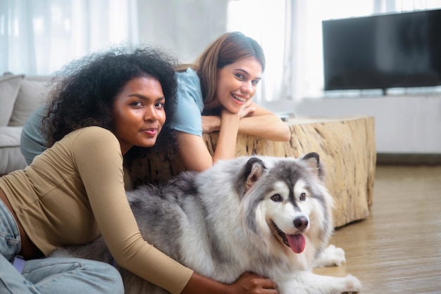 Family LGBT diversity lesbian couple with dog in room LGBT lifestyle