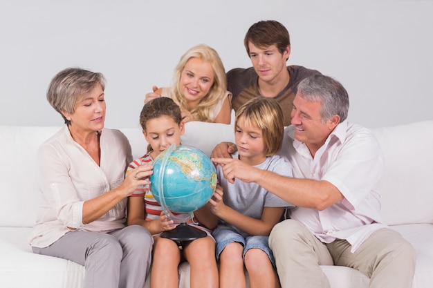 Family looking at globe on couch