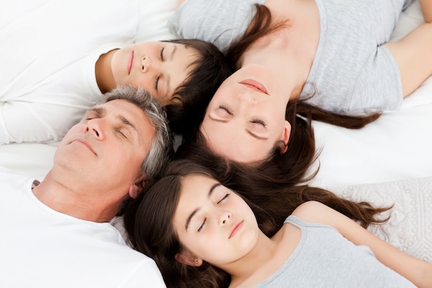 Family  lying down on their bed