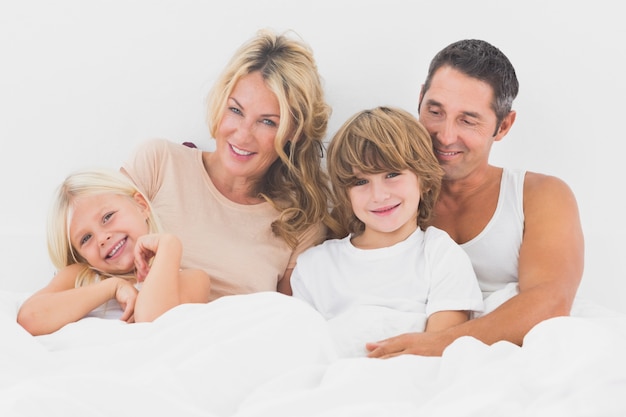 Family lying on a white bed