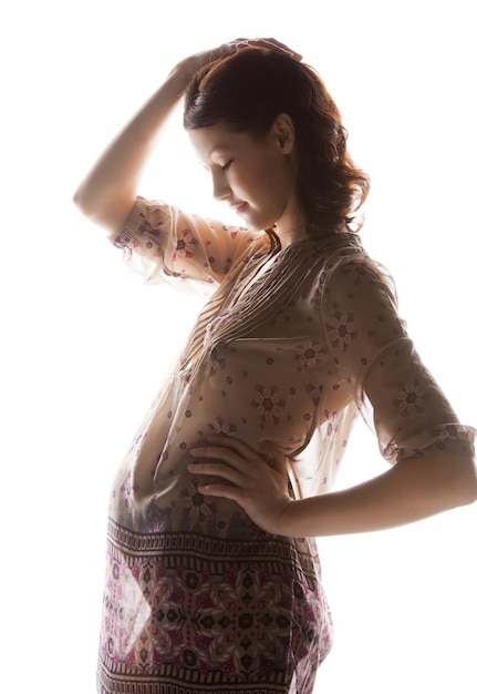 family, motherhood and pregnancy concept - silhouette backlight picture of pregnant beautiful woman