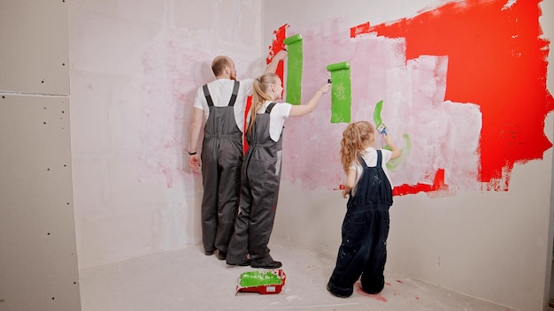 Family painting walls in the new apartment in green color