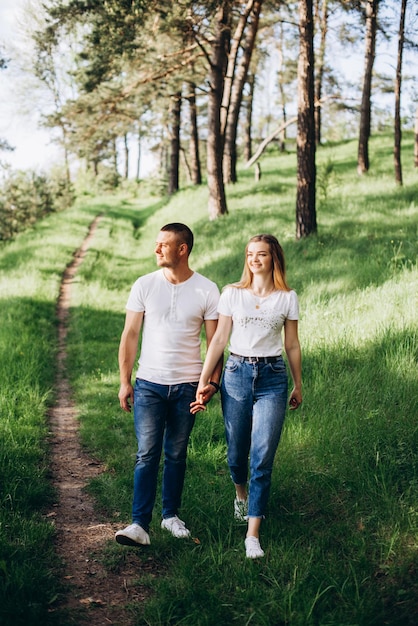 Family photo session on the street on a warm sunny day in a coniferous forest in spring