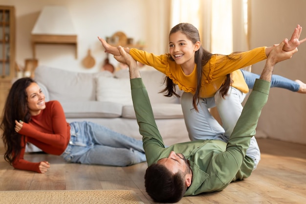 Family playing airplane game in the living room