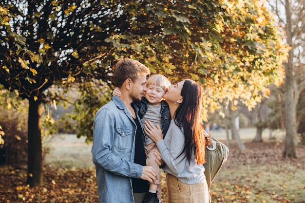 Family playing in autumn park having fun
