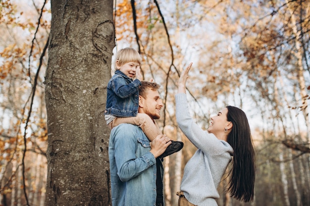 Family playing in autumn park having fun
