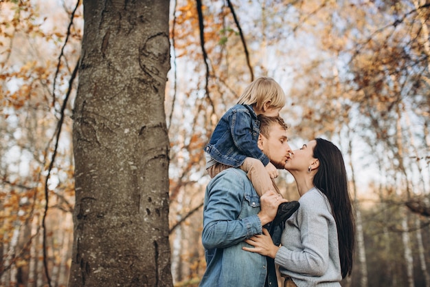 Family playing in autumn park having fun
