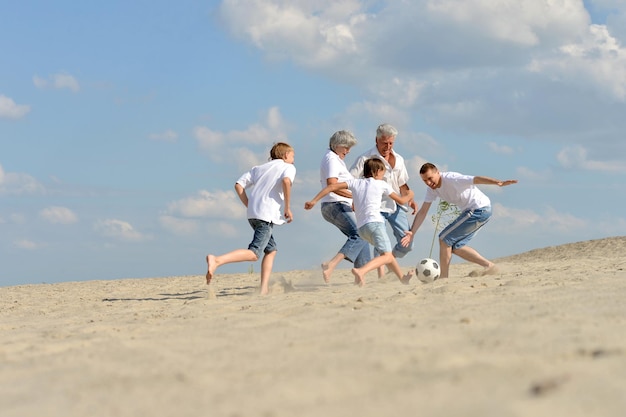 Family playing football on a beach