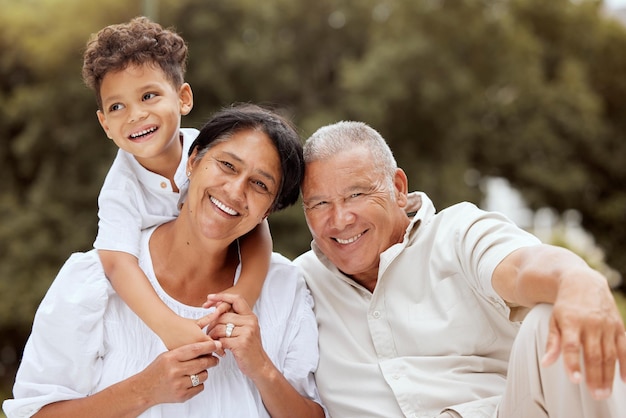 Family portrait and relax at a park with grandparents and grandchild playing laughing and bond in nature Love happy family and senior couple enjoy retirement with little boy in a garden in Mexico