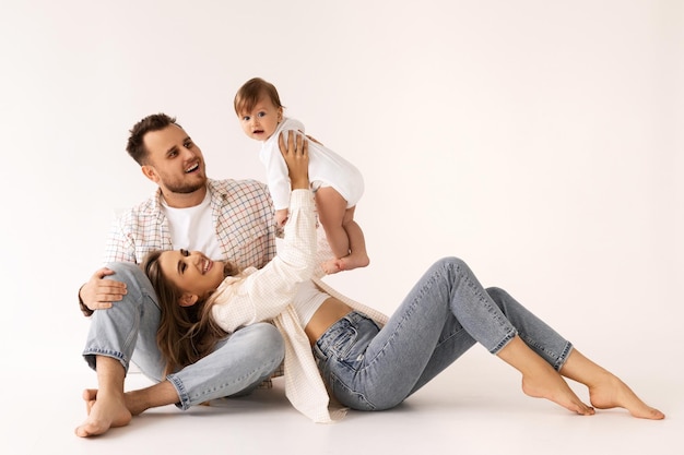 family portrait on a white background, happy family concept portrait. the parents play with the chil