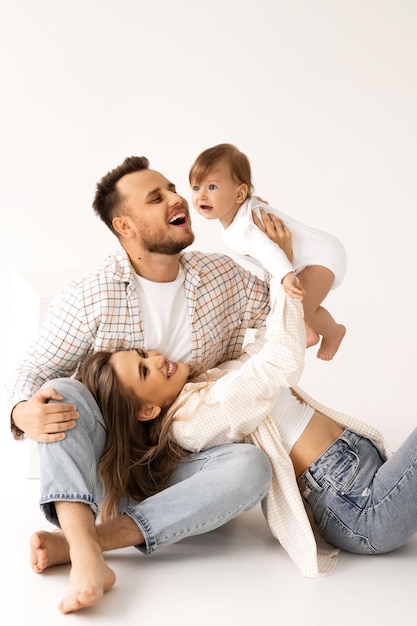 family portrait on a white background, happy family concept portrait. the parents play with the chil