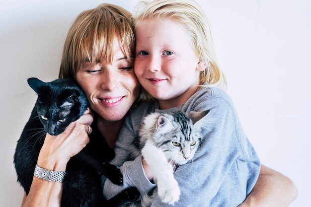 Family portrait with caucasian mother blonde beautiful middle age woman and young white skin son and two lovely adorable cats group hug with persons and animals best friends forever together concept