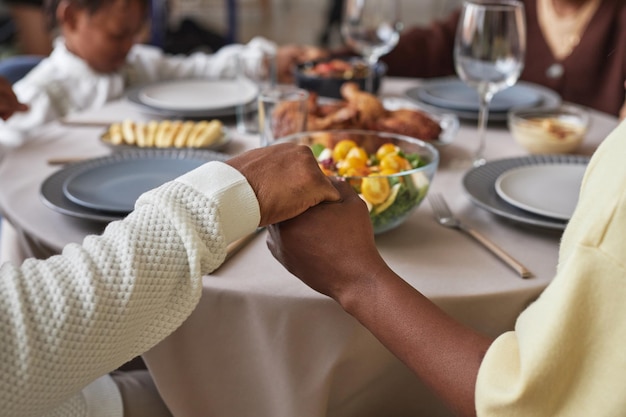 Family praying at dining table