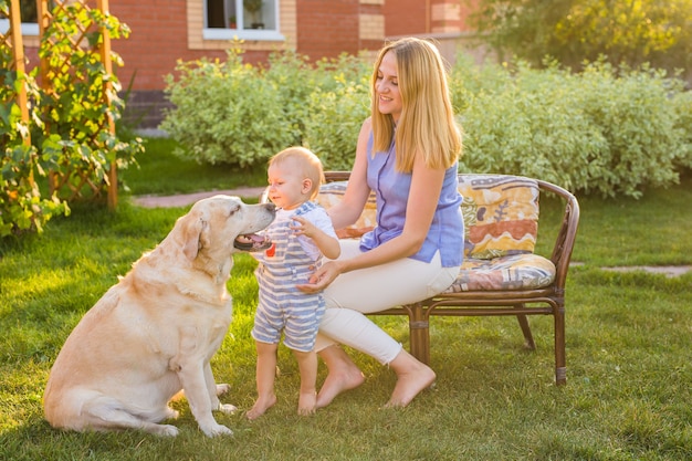 Family Relaxing In Garden With Pet Dog.