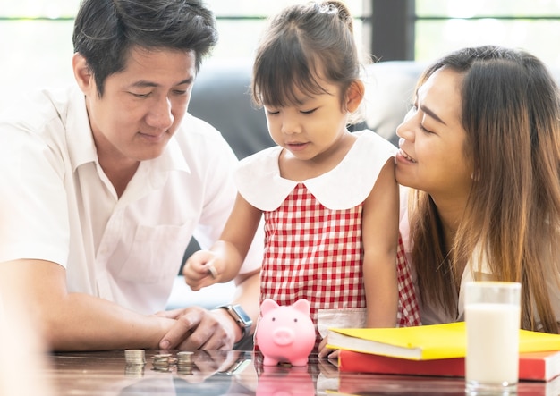 Family saving money to piggy bank