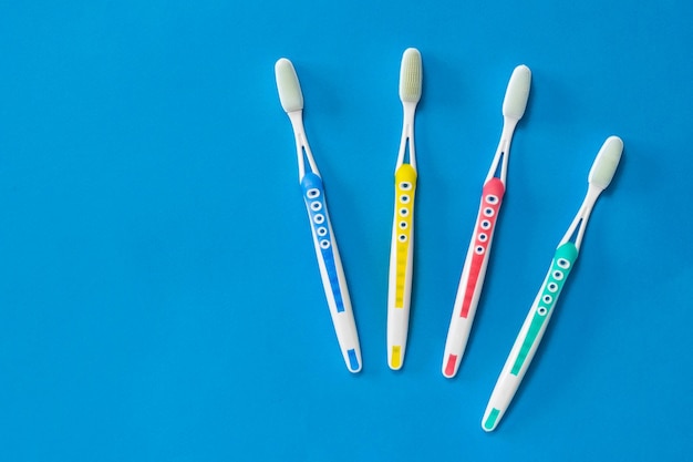 Family set of toothbrushes with silicone bristles on a blue background. Concept of oral hygiene in the family. Means to care for the oral cavity.