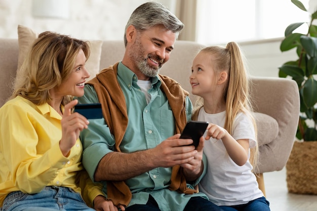 Family shopping paying online using phone and credit card indoor