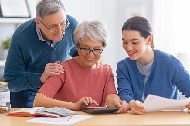 Family sitting at the desk with a paper receipt are calculating expenses, managing the family budget.