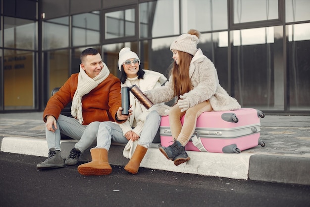 Family sitting outdoors on a luggage and waiting for travel