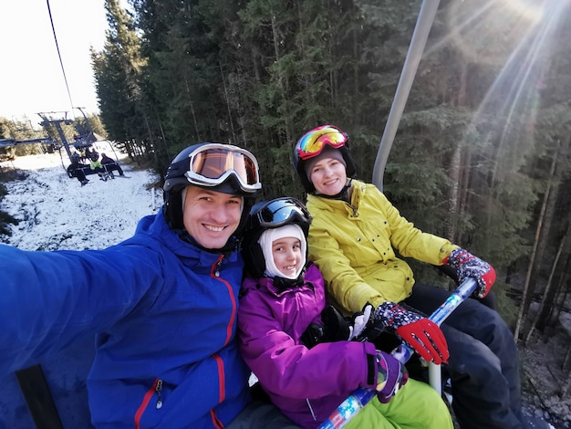 family on the ski lift in the mountains