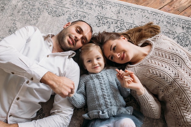 Family smiling while lying on the floor at home